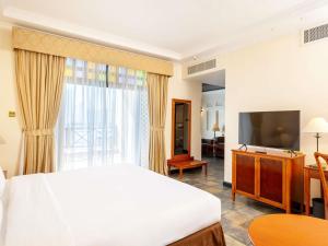 a hotel room with a bed and a television at Novotel Bahrain Al Dana Resort in Manama