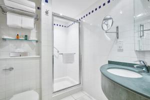 a white bathroom with a sink and a shower at Hilton Garden Inn Bristol City Centre in Bristol