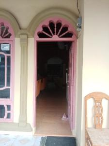 un corridoio di una casa con porta rosa di Aurora Baji 