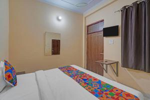 FabHotel Hare Rama في Prayagraj: غرفة فندق بها سرير ونافذة