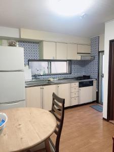 東京にあるTokyo Kakanのテーブルと白い冷蔵庫のあるキッチン