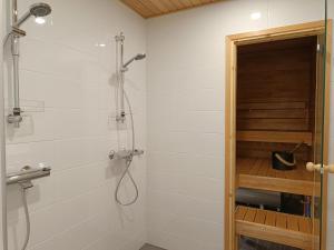 een badkamer met een douche met een glazen deur bij Syötemaja in Pudasjärvi +23 foto's