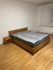 een bed in een kamer met een houten vloer bij Ubytovanie u Grófa in Turany