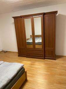 een slaapkamer met een grote houten kast met spiegels bij Ubytovanie u Grófa in Turany +2 foto's