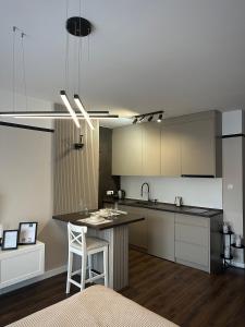 een keuken met een eiland en een bar bij Premium Line Apartman 3 in Sombor