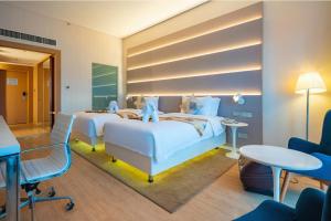 a hotel room with two beds and a desk at Sanya Phoenix Airport Hotel in Sanya +32 photos