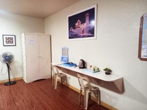 a room with a table and two chairs and a wall at Minine Guesthouse in Silang