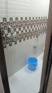 ein Badezimmer mit einem blauen Eimer in der Dusche in der Unterkunft Shri Ram Bhavan Homestay in Varanasi