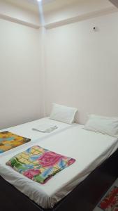 ein weißes Bett mit zwei Kissen darüber in der Unterkunft Shri Ram Bhavan Homestay in Varanasi
