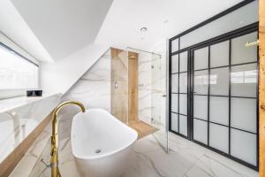 厄尔科H Aparthotel的带白色浴缸和淋浴的浴室 更多27张照片