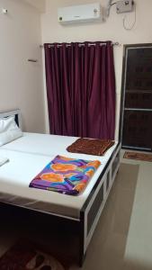 Bett in einem Zimmer mit einem lila Vorhang in der Unterkunft Shri Ram Bhavan Homestay in Varanasi