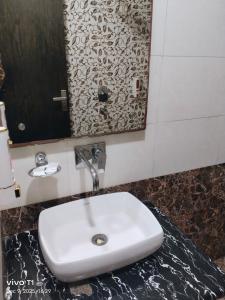 a white sink in a bathroom with a mirror at Tejas stay in New Delhi