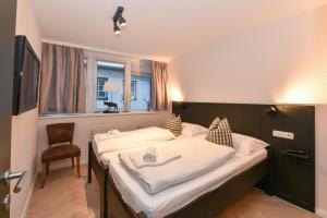 a bedroom with a bed with a chair and a window at Penthouse Mountain and Lake View, terrace, AirCondition, incl Summer Card in Zell am See