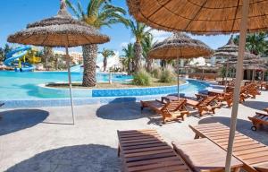 Soviva的一个带椅子和遮阳伞的游泳池的度假酒店