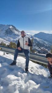 Soviva的一个男人坐在雪地里的栏杆上