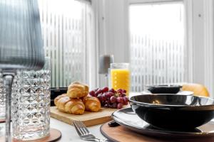 una mesa con un plato de pan y un tazón de zumo de naranja en Modern 2bed Flat 5 min walk to Brixton & Clapham, en Londres 28 fotos más