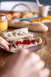 a person holding a plate with two slices of bread at Roulotte avec bain nordique privatif chauffé, Séjour calme et bien-être in Fichous-Riumayou +14 photos