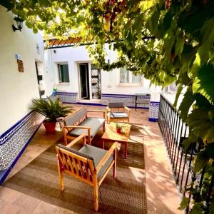 a patio with benches and tables on a building at DescubreHome La Casa del Medico in Aznalcázar