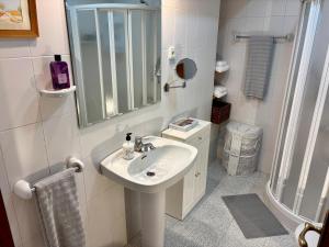 a white bathroom with a sink and a shower at DescubreHome La Casa del Medico in Aznalcázar +14 photos