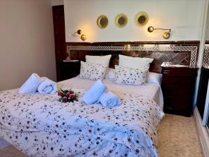 a bedroom with two beds with towels and flowers on them at DescubreHome La Casa del Medico in Aznalcázar