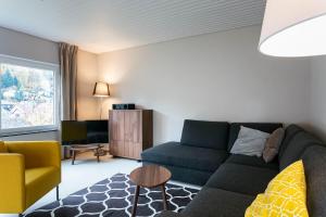 a living room with a couch and a tv at Haus am Sagenweg in Nothweiler