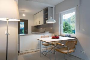 a kitchen with a table and chairs and a window at Haus am Sagenweg in Nothweiler +14 photos