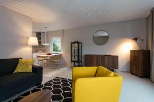 a living room with a yellow couch and a table at Haus am Sagenweg in Nothweiler