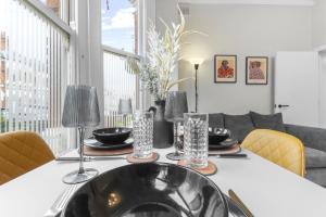 Una mesa de comedor con fregadero y sillas. en Modern 2bed Flat 5 min walk to Brixton & Clapham, en Londres