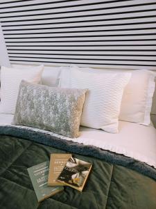 a bed with white pillows and a book on it at Marinella House Napoli centro Piazza Dante in Naples