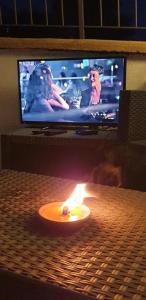eine Kerze auf einem Tisch vor einem Fernseher in der Unterkunft B&B L'incanto del Golfo in Agropoli