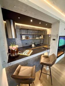 a kitchen with two chairs and a counter top at smgold lux apartman in Podgorica