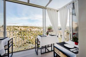 a dining room with a table and chairs and a large window at Casa Festa Rooms in Matera