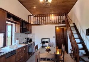 Kitta Mani Towerhouse - Mountain Views & Garden في Koíta: مطبخ مع طاولة و درج في الغرفة