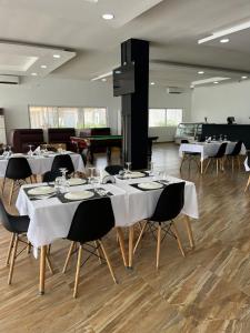 Decifer Sport Resort في Belas: غرفة طعام مع طاولات وكراسي بيضاء