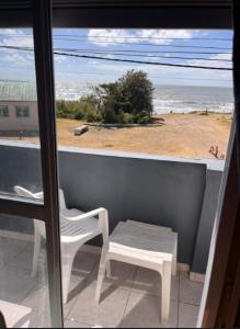 Hotel Romalu في سانتا تيريسيتا: شرفة مع طاولة وكراسي وإطلالة على الشاطئ