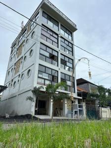 a tall white building with a lot of windows at On The Moon in Ketewel +8 photos