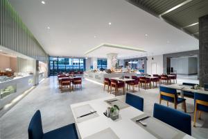 an open dining room with tables and chairs at Sanya Phoenix Airport Hotel in Sanya