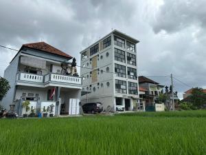 a tall white building next to a field of grass at On The Moon in Ketewel