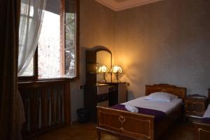 a bedroom with a bed and a window at European Backpackers in Tbilisi City