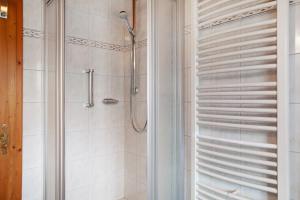 a bathroom with a shower with a glass door at Ferienwohnung Alpspitze in Grainau +23 photos