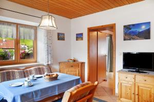 a living room with a table and a television at Ferienwohnung Alpspitze in Grainau
