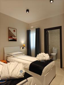 a hotel room with two beds and a mirror at Veduta Ta Pinu Apartments with Stunning Views Garden Sauna Pool and Gym in Għarb +60 photos