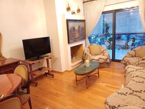 a living room with a tv and a couch and a table at Mary's vintage house in Athens