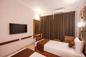 a hotel room with a bed and a television at U by Z Hotels, Richmond Circle in Bangalore +39 photos