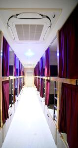 een kleedkamer met paarse gordijnen en een gang bij Umaa Sleeping Beds Dormitory in Pārvatīpuram