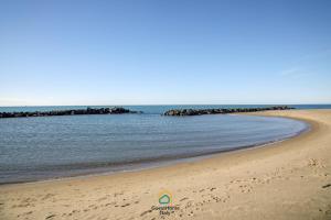a beach with a rock formation in the water at Dani's House in Isola Sacra +2 photos