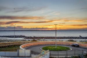 a car driving down a road next to the ocean at Dani's House in Isola Sacra