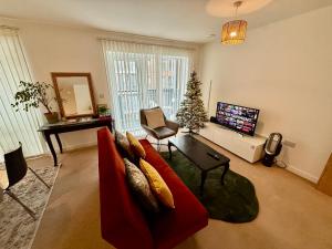 a living room with a red couch and a christmas tree at Issara Apartments 49 - Great location & Private Parking in Portsmouth