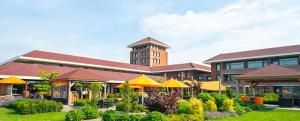 a building with yellow umbrellas in front of it at Hotel van der Valk Wolvega-Heerenveen in Wolvega