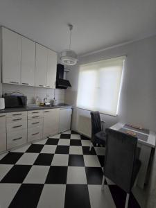 una cucina con pavimento a scacchi in bianco e nero di Apartman Rada 3 a Bijeljina